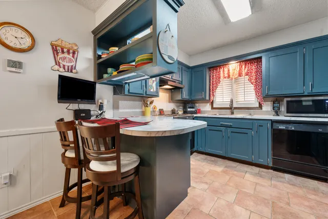 a kitchen with a sink cabinets and dining table