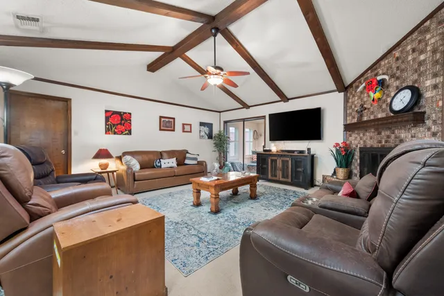 a living room with furniture a flat screen tv and a couch