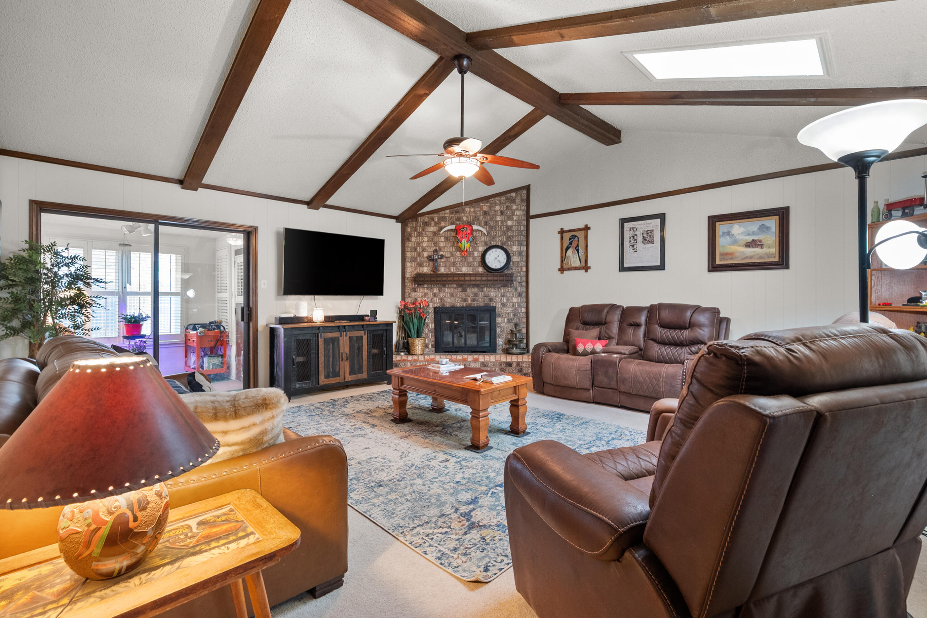 4610 63rd Street Lubbock, TX 79414 - Photo 9 of 30 a living room with furniture a flat screen tv and a fireplace
