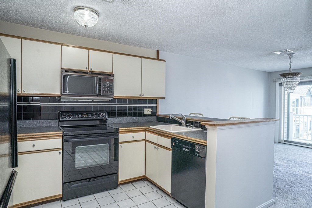 700 Shore Drive, Unit 511 Fall River, MA 02721 - Photo 9 of 40 a kitchen with stainless steel appliances granite countertop a stove a sink and a microwave