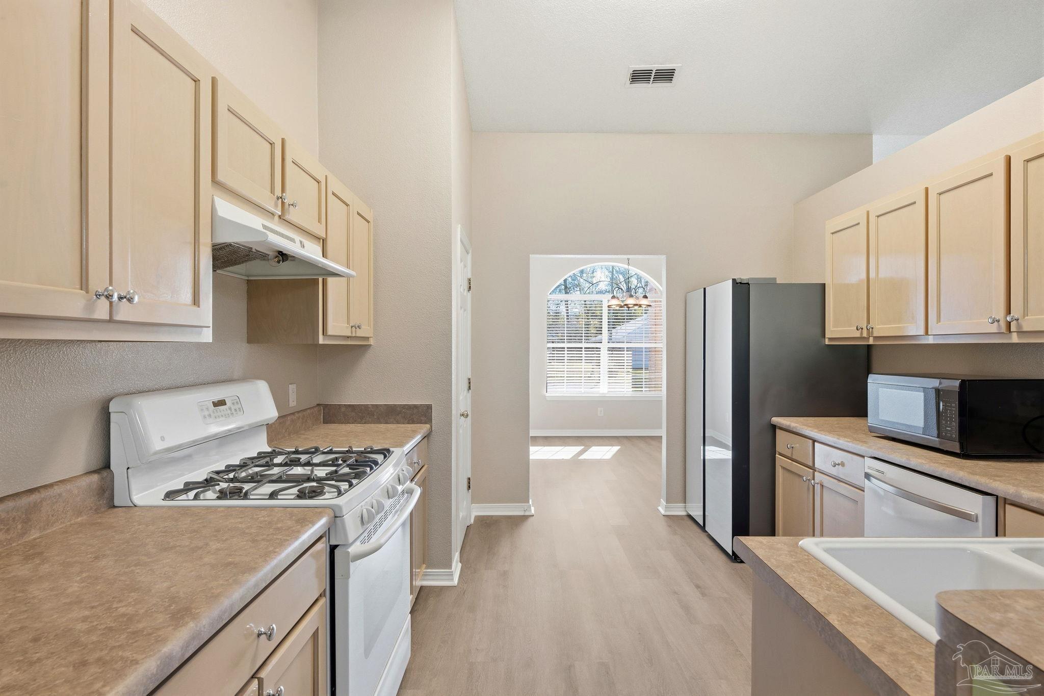 1844 Wareham Way Cantonment, FL 32533 - Photo 12 of 47 a kitchen with stainless steel appliances a stove a sink a refrigerator and cabinets