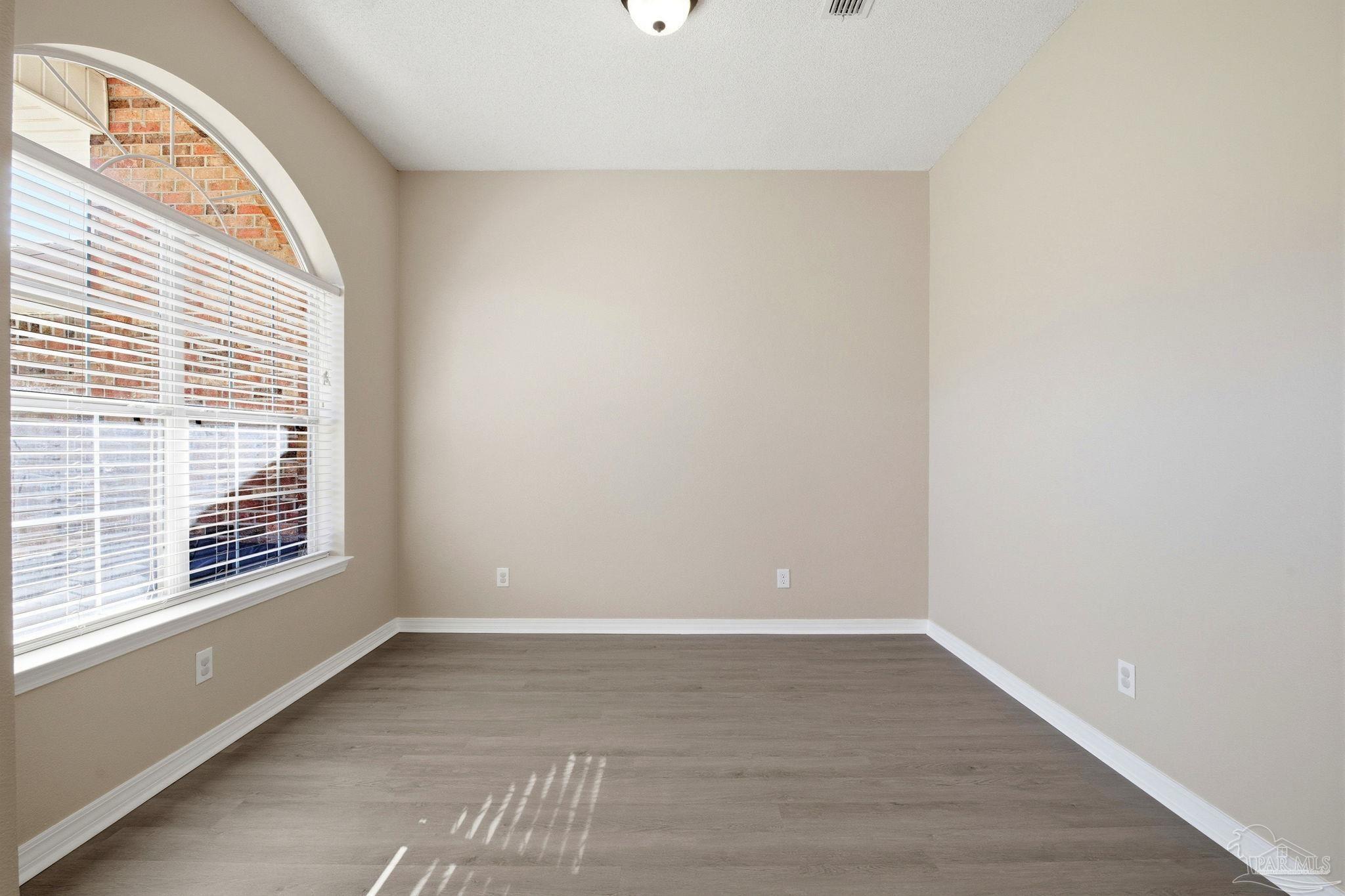 1844 Wareham Way Cantonment, FL 32533 - Photo 18 of 47 a view of an empty room with wooden floor and a window
