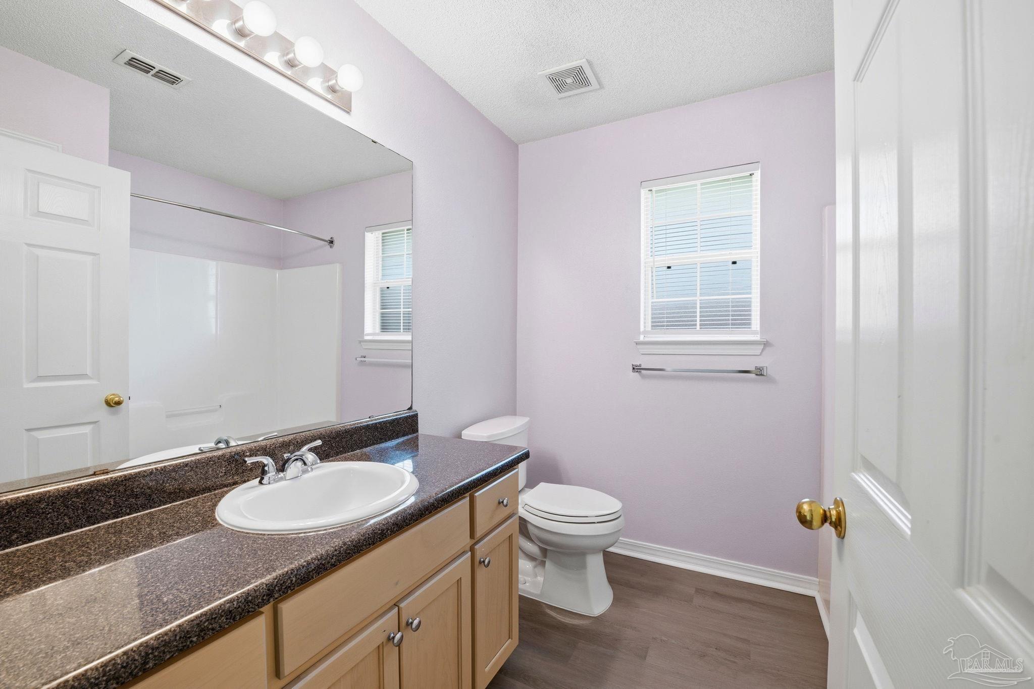 1844 Wareham Way Cantonment, FL 32533 - Photo 35 of 47 a bathroom with a granite countertop sink a toilet and a mirror