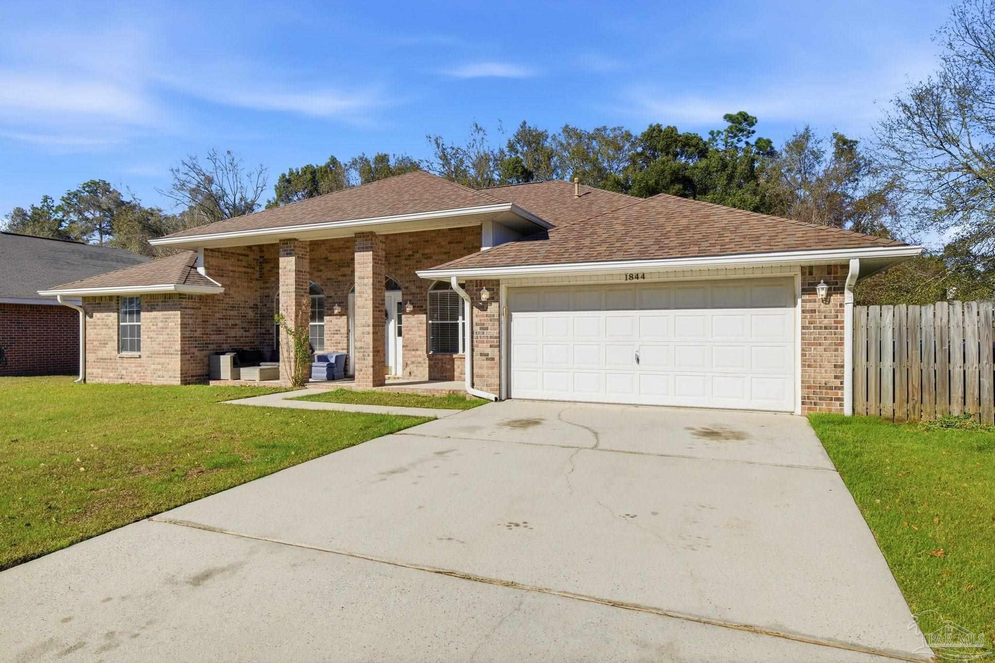 1844 Wareham Way Cantonment, FL 32533 - Photo 46 of 47 a view of a white house with a yard and potted plants