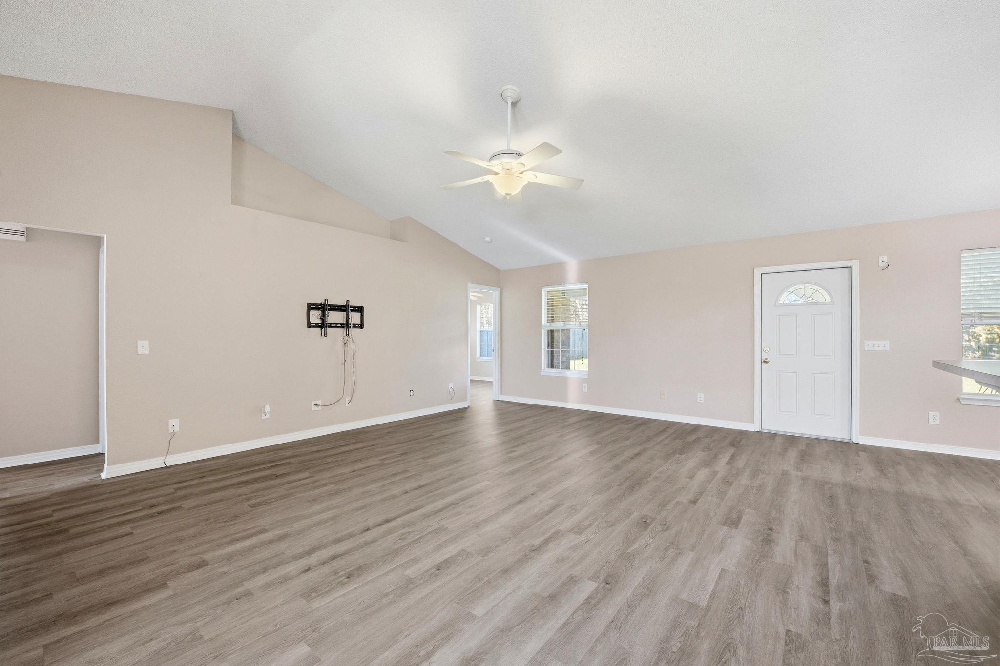 1844 Wareham Way Cantonment, FL 32533 - Photo 5 of 47 an empty room with wooden floor chandelier fan and windows