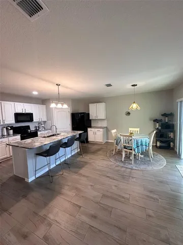 a living room with furniture a flat screen tv and kitchen view