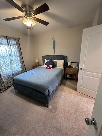 a bedroom with a bed and a ceiling fan