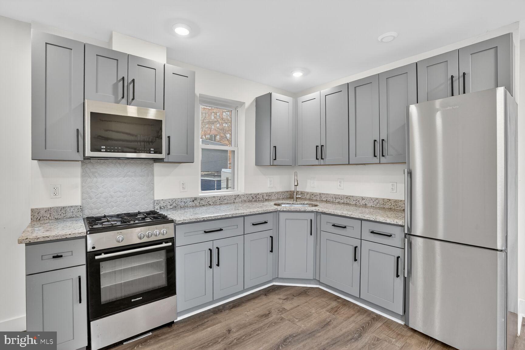 1821 T Street Northwest Washington, DC 20009 - Photo 12 of 40 a kitchen with cabinets stainless steel appliances and a wooden floor