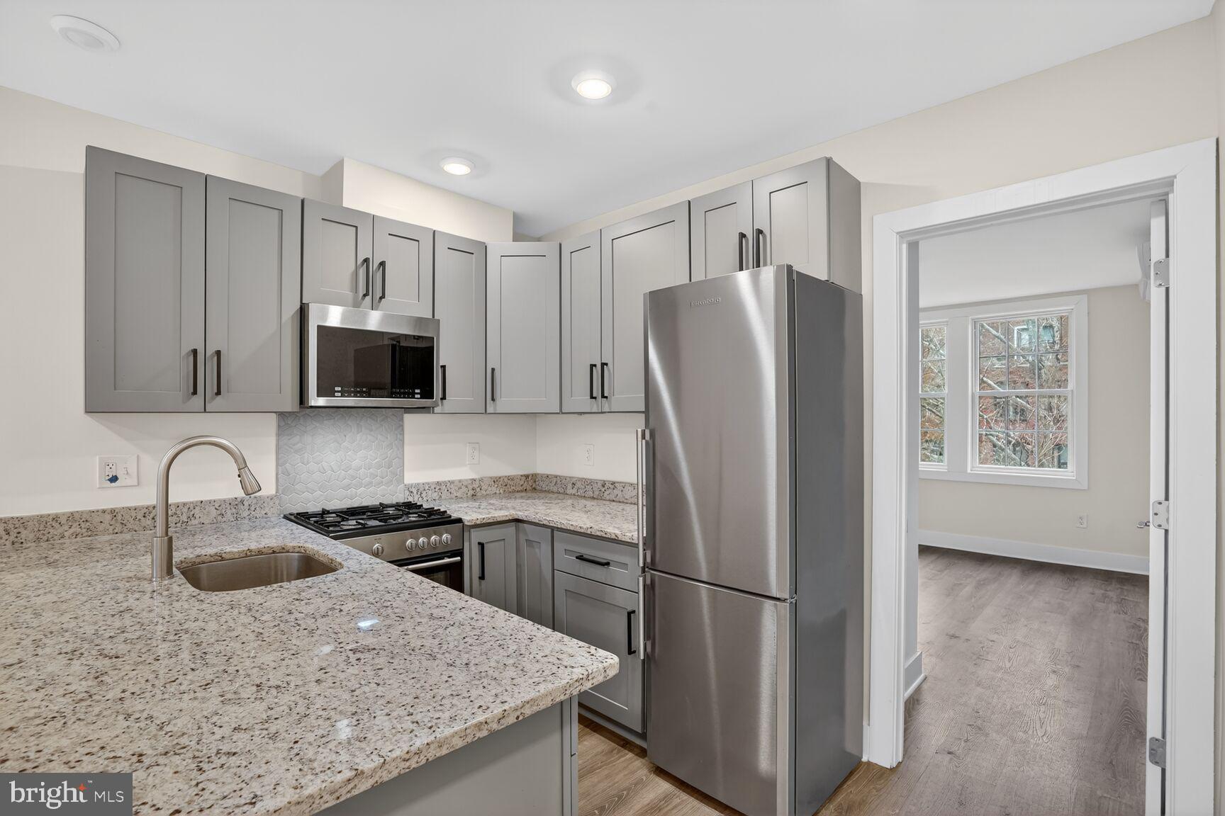 1821 T Street Northwest Washington, DC 20009 - Photo 29 of 40 a kitchen with stainless steel appliances granite countertop a refrigerator sink and stove