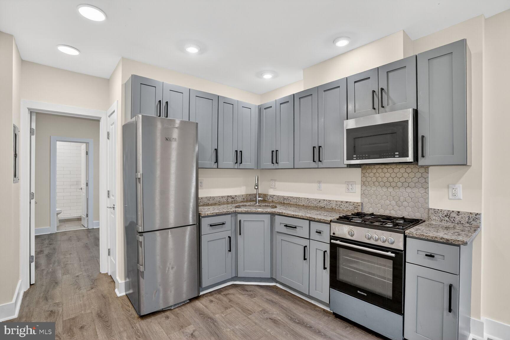 1821 T Street Northwest Washington, DC 20009 - Photo 5 of 40 a kitchen with stainless steel appliances granite countertop a refrigerator stove and sink