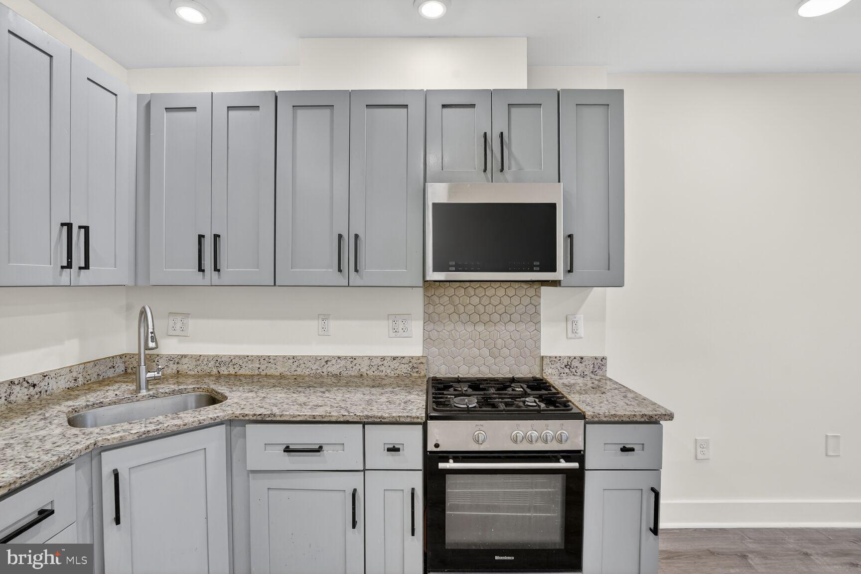 1821 T Street Northwest Washington, DC 20009 - Photo 6 of 40 a kitchen with granite countertop a sink stove and cabinets