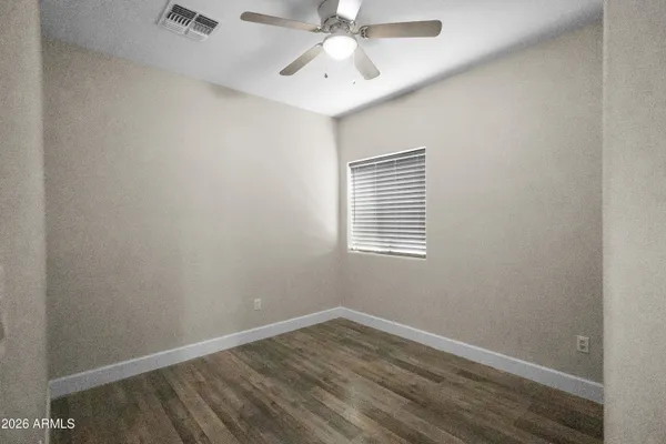 an empty room with a window and a ceiling fan