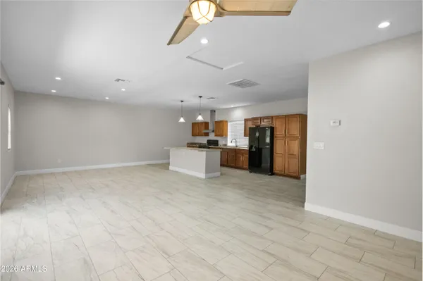 a view of kitchen with stainless steel appliances refrigerator stove and wooden floor