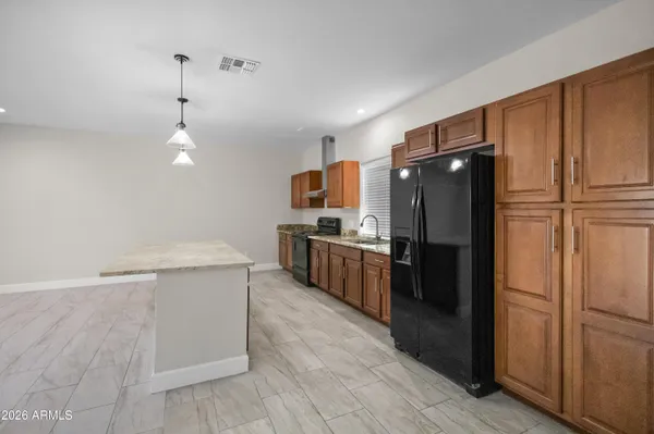 a kitchen with kitchen island a counter top space stainless steel appliances and cabinets