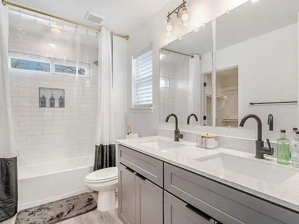 a bathroom with a sink a toilet a mirror and shower