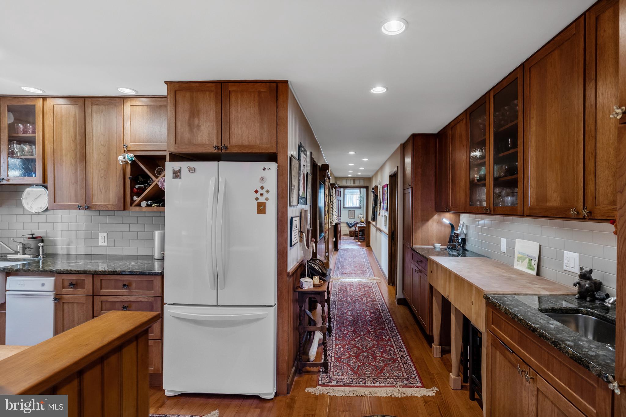 444 Shady Lane Moorestown, NJ 08057 - Photo 18 of 46 a kitchen with granite countertop a refrigerator a sink and wooden cabinets
