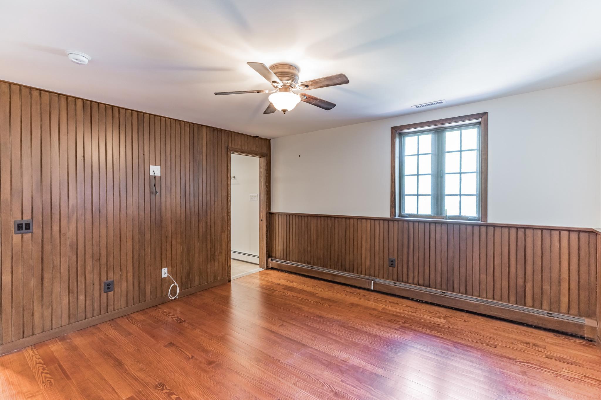 444 Shady Lane Moorestown, NJ 08057 - Photo 19 of 46 an empty room with wooden floor chandelier fan and windows