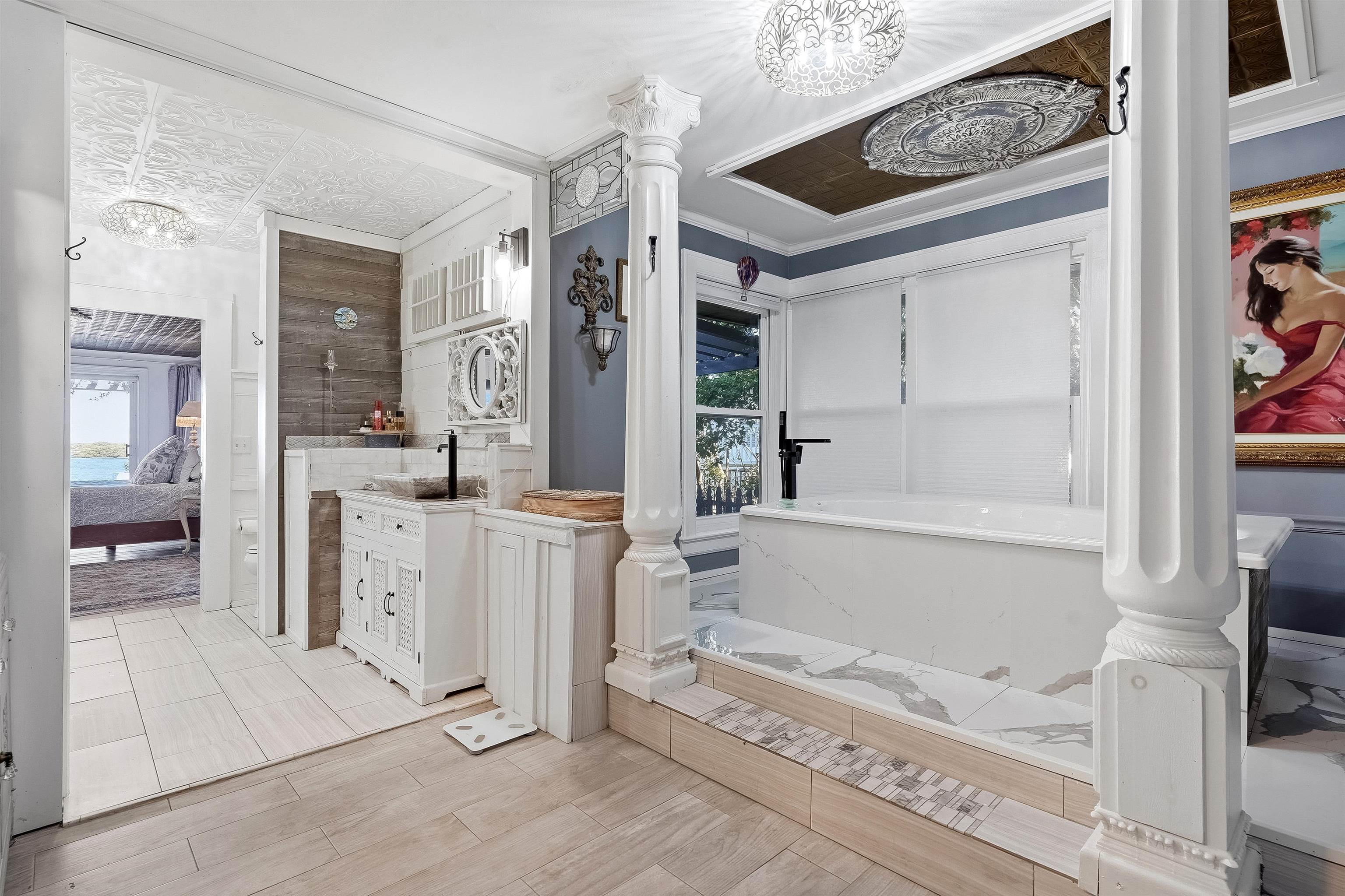 71 Water Street St. Augustine, FL 32084 - Photo 11 of 57 Ensuite bathroom featuring vanity, a bath, crown molding, a chandelier, and decorative columns