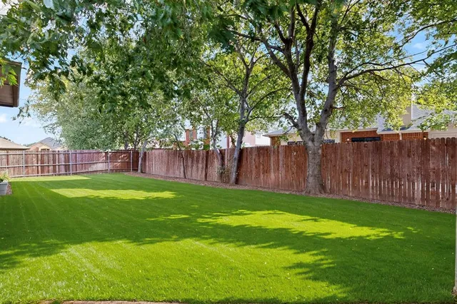 a view of yard with green space and wooden fence