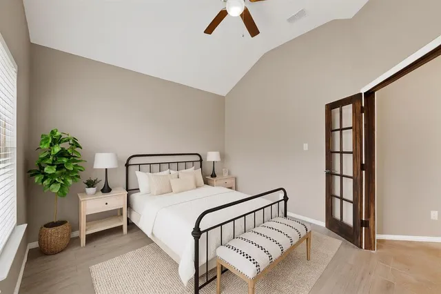 a bedroom with a bed and a potted plant on the dresser