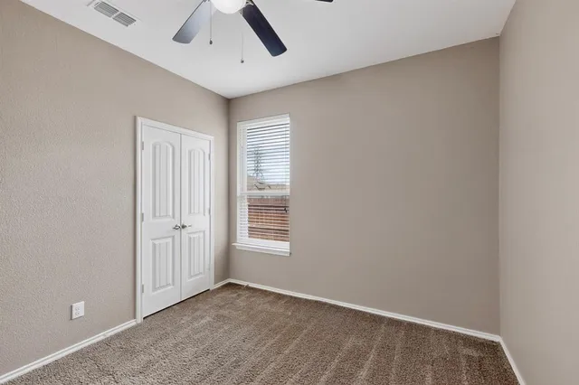 an empty room with windows and closet