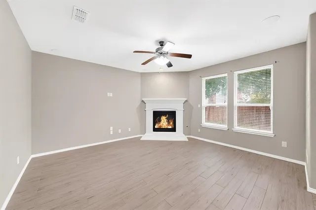 a view of an empty room with a window and fireplace