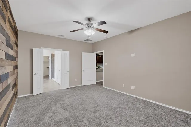 a view of an empty room with a ceiling fan
