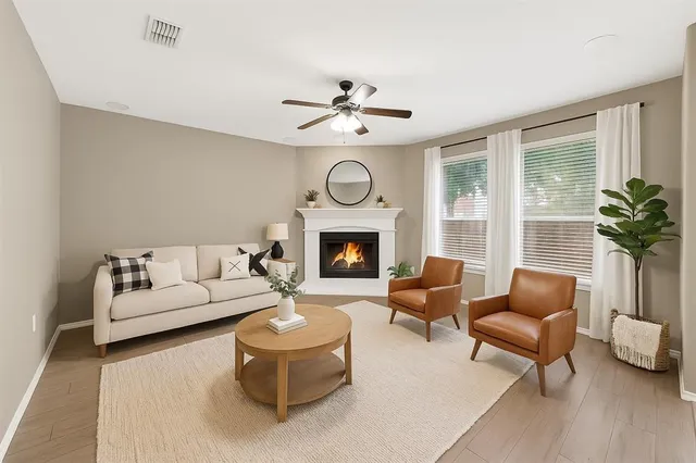 a living room with furniture a fireplace and a large window