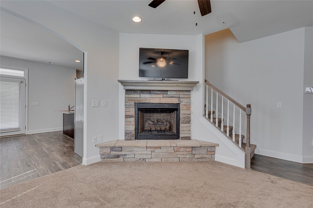 141 Capslock Trail Pendleton, SC 29670 - Photo 16 of 38 A corner stone fireplace anchors this living space, offering warmth and visual appeal.