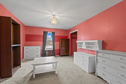 a spacious bedroom with a bed and a dresser