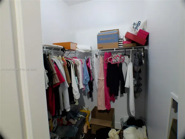 a view of walk in closet with clothes