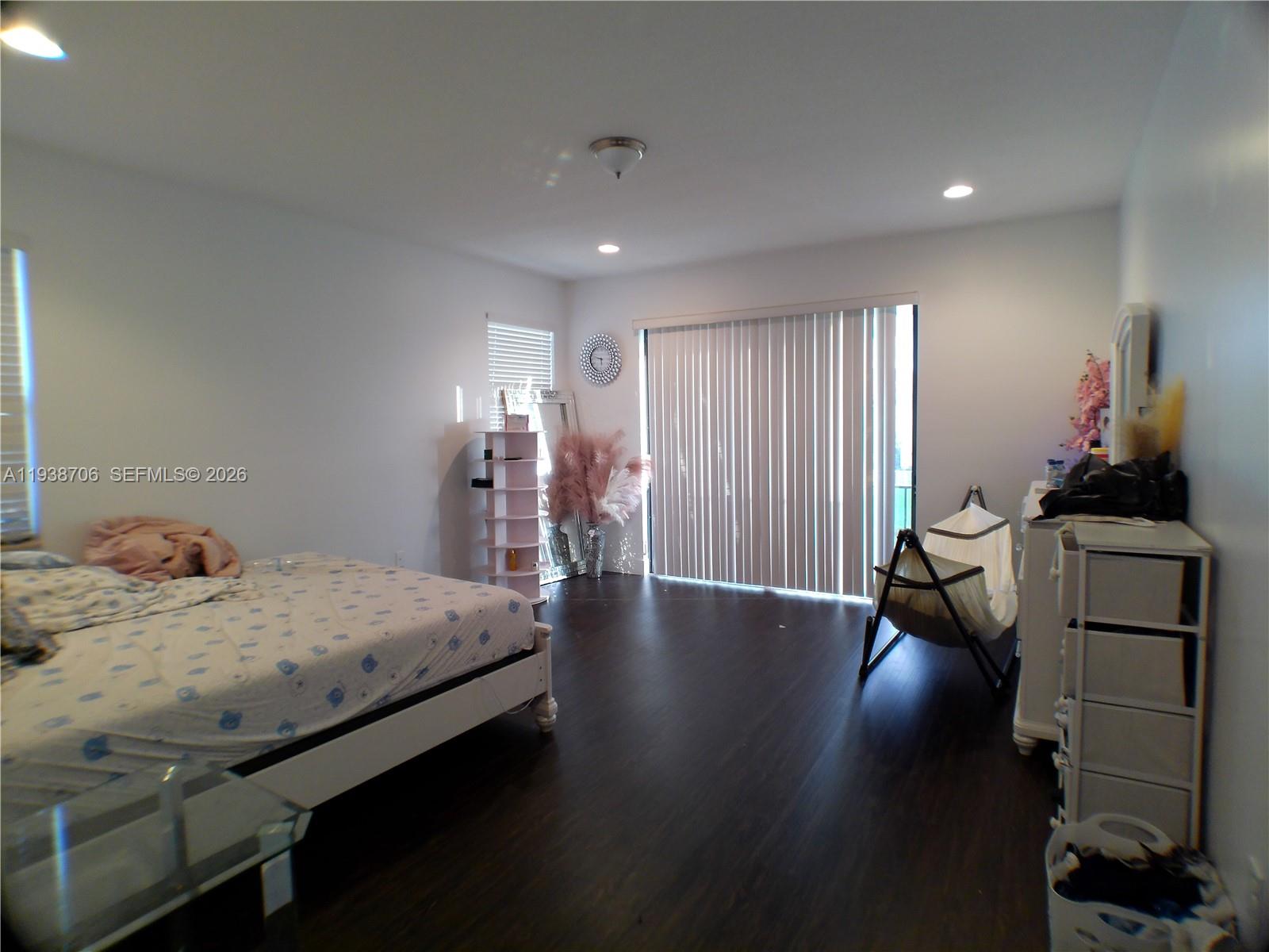 3308 West 95th Terrace Hialeah, FL 33018 - Photo 16 of 29 a bed room with a bed and a chandelier