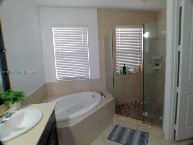 a bathroom with a granite countertop sink and a bathtub
