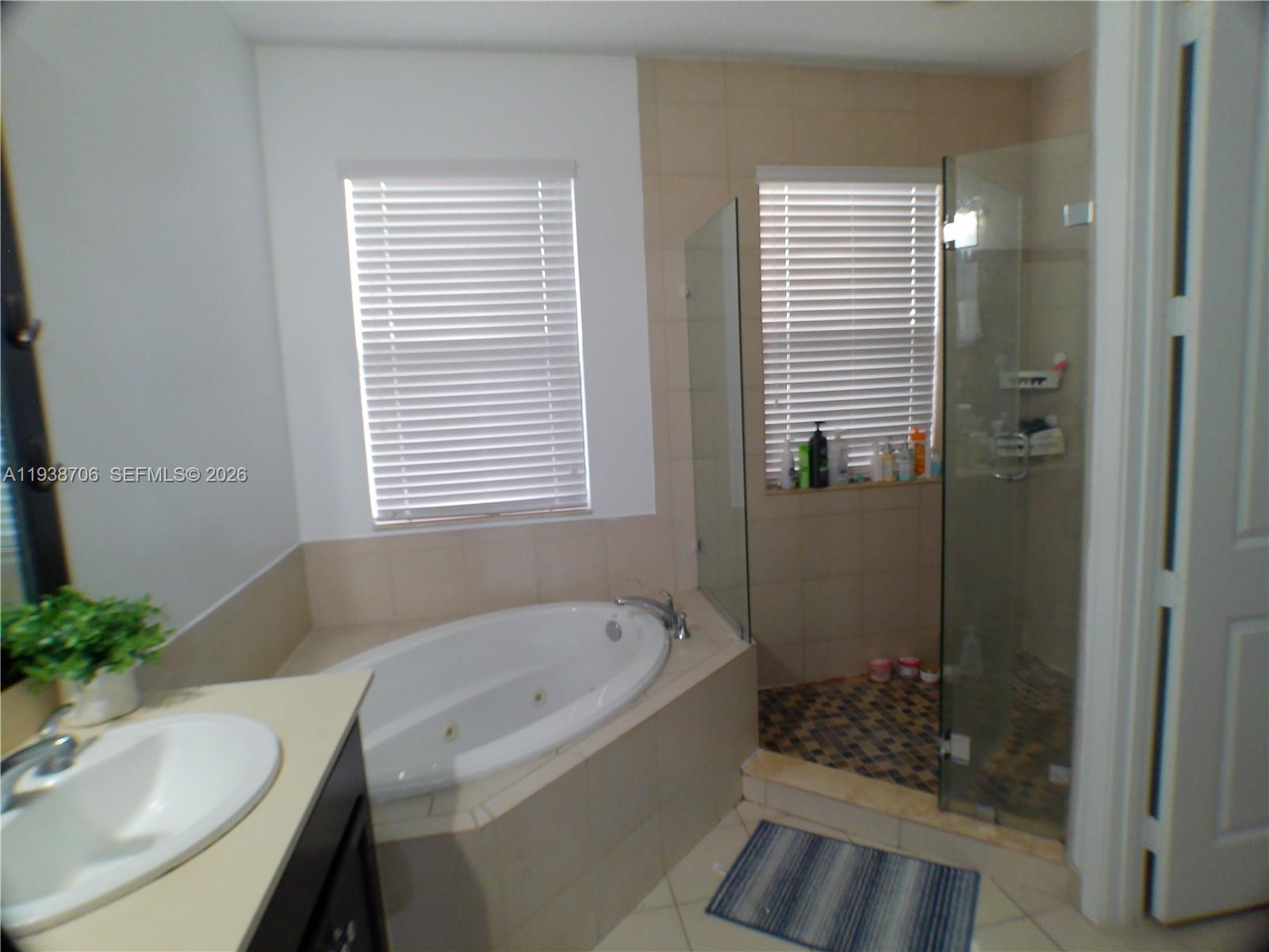 3308 West 95th Terrace Hialeah, FL 33018 - Photo 19 of 29 a bathroom with a granite countertop sink and a bathtub
