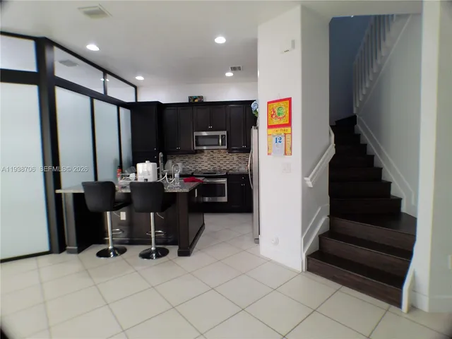 a view of kitchen with furniture and stainless steel appliances