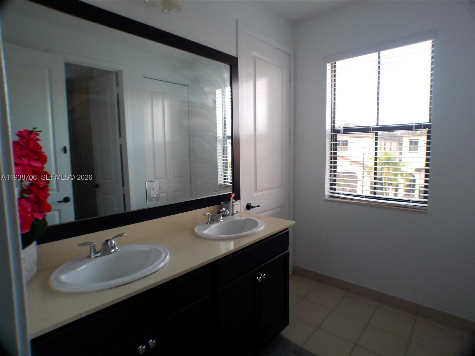 3308 West 95th Terrace Hialeah, FL 33018 - Photo 23 of 29 a bathroom with a double vanity sink and a mirror