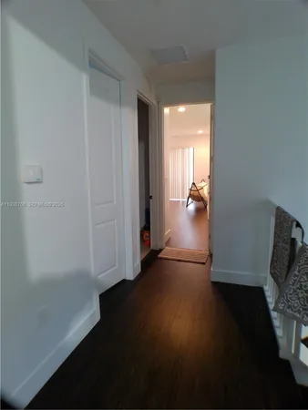 a view of hallway with livingroom and wooden floor