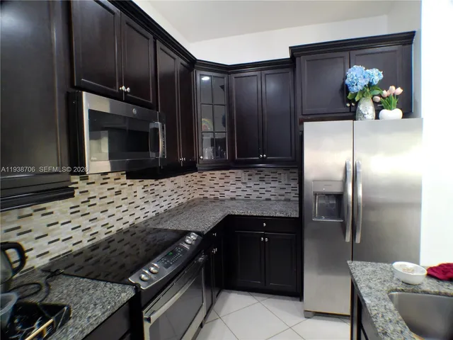 a kitchen with granite countertop stainless steel appliances and wooden cabinets