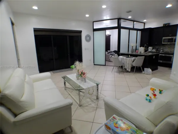 a living room with furniture and kitchen view