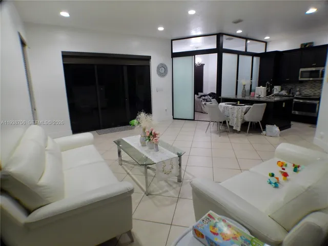 a living room with furniture and kitchen view