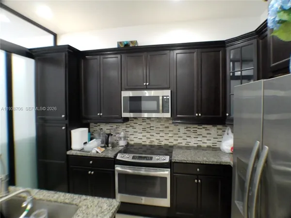 a kitchen with stainless steel appliances wooden cabinets and a sink