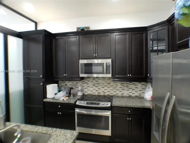 a kitchen with stainless steel appliances wooden cabinets and a sink