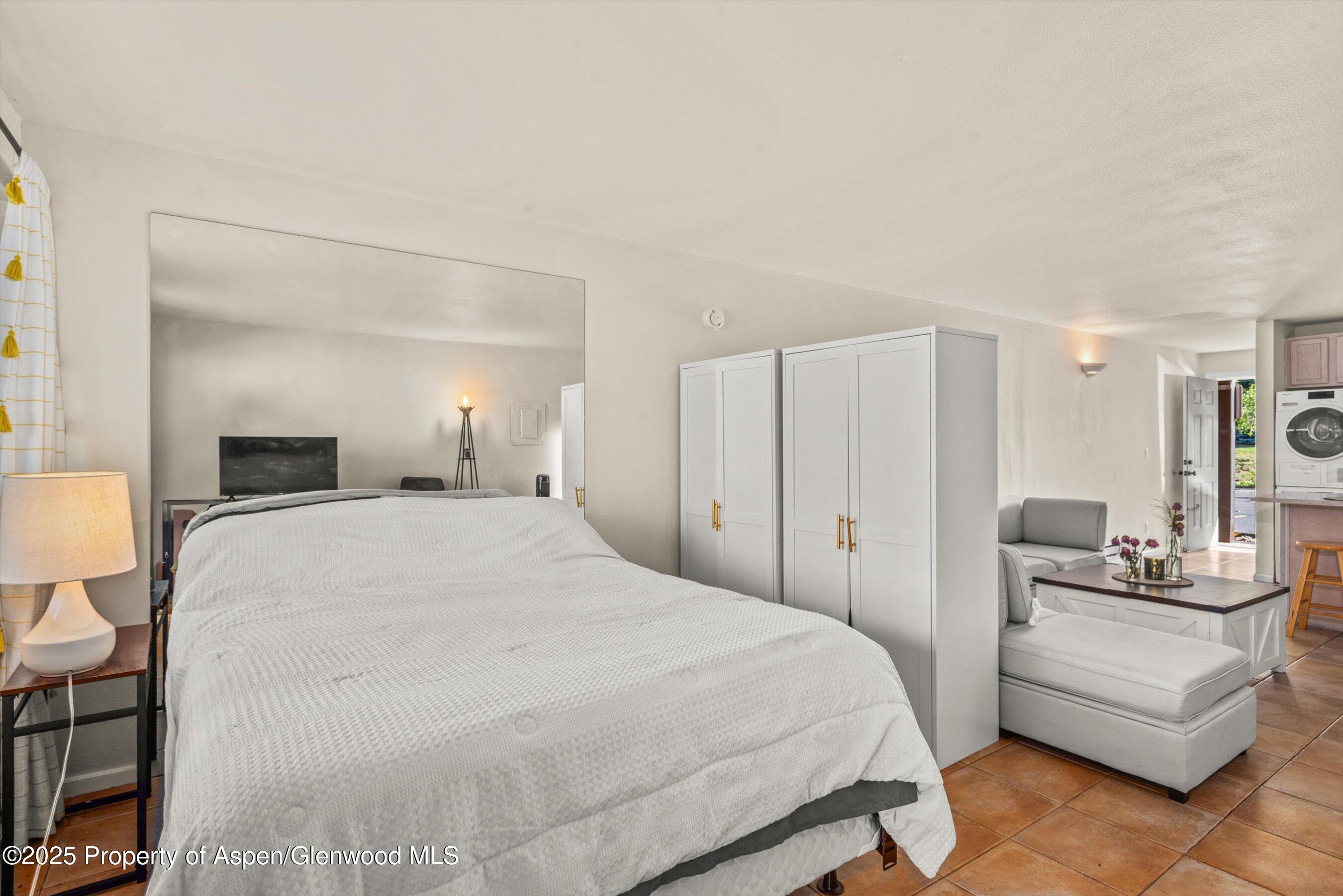 23284 2 Rivers Road, Unit 13 Basalt, CO 81621 - Photo 11 of 16 a bedroom with a bed a mirror and lamp