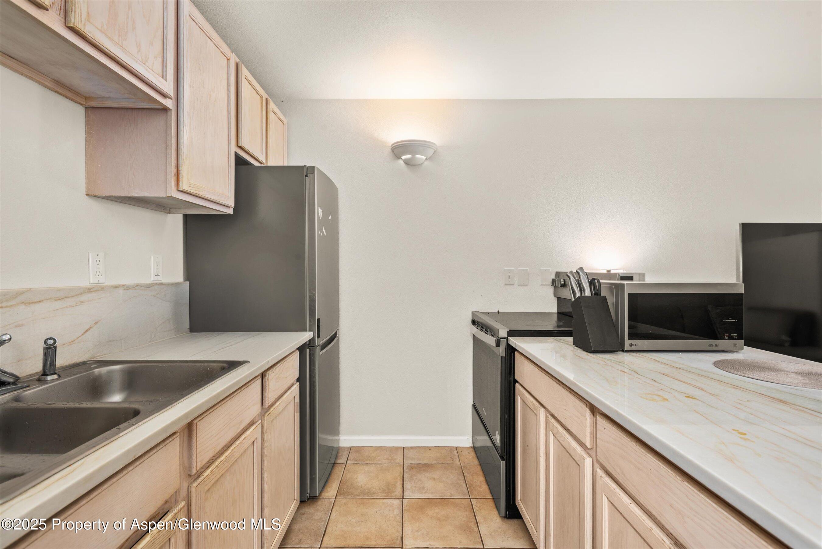 23284 2 Rivers Road, Unit 13 Basalt, CO 81621 - Photo 7 of 16 a kitchen with granite countertop a sink stove and refrigerator
