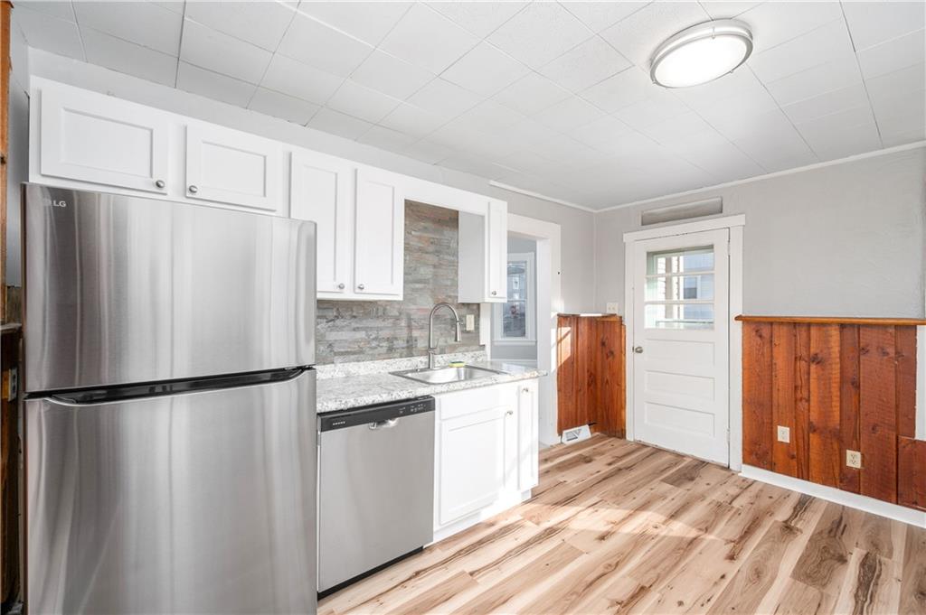 401 West New Castle Street Butler, PA 16001 - Photo 14 of 32 a kitchen with stainless steel appliances granite countertop a refrigerator sink and white cabinets