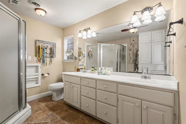 a bathroom with a double vanity sink a toilet and a mirror