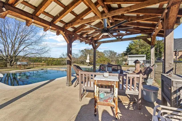 a view of a patio with dining table and chairs with wooden floor
