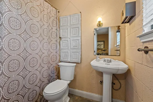 a bathroom with a toilet sink and mirror