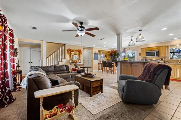 a living room with furniture a ceiling fan and a rug