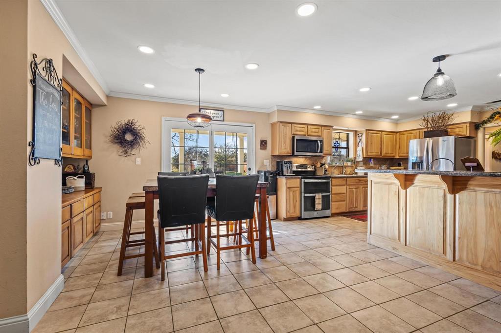 2321 County Road 2100 Ivanhoe, TX 75447 - Photo 5 of 40 a kitchen with cabinets and chairs